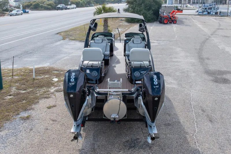 Slide: The Image of 2024 Manitou 25 LX SRW Dual Engine boat with twin 300 V8 engines, parked on pavement. - 18