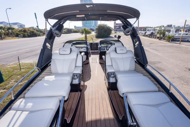 Slide: The Image of 2024 Manitou 25 LX SRW Dual Engine boat with luxurious seating and sleek design. - 21