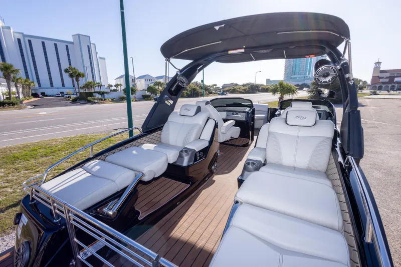 Slide: The Image of 2024 Manitou 25 LX SRW Dual Engine boat with luxurious white seating and sleek design. - 23