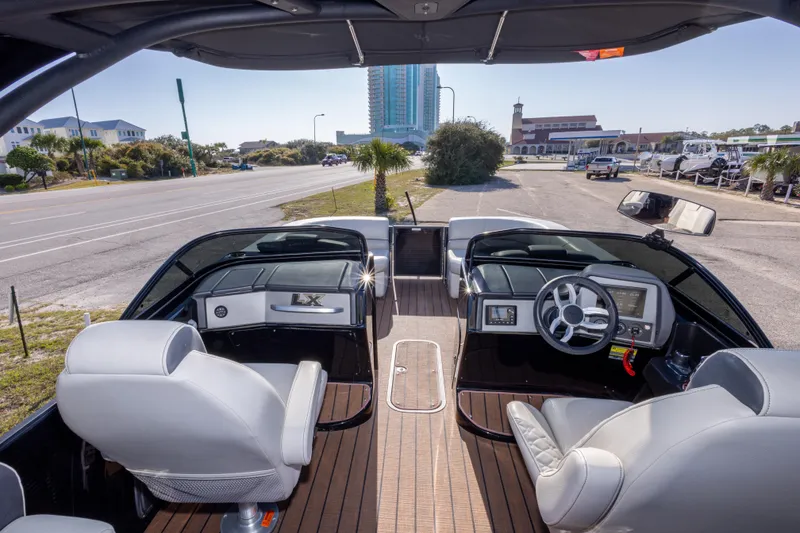 Slide: The Image of 2024 Manitou 25 LX SRW Dual Engine boat interior with modern dashboard and seating. - 26