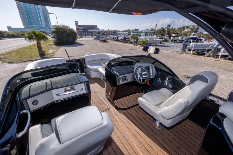 Slide: The Image of 2024 Manitou 25 LX SRW Dual Engine boat interior with modern seating and dashboard. - 27