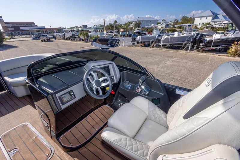 Slide: The Image of 2024 Manitou 25 LX SRW Dual Engine boat interior with modern dashboard and luxurious seating. - 28