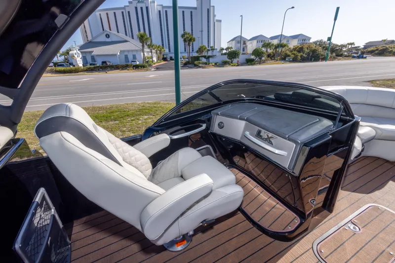 Slide: The Image of 2024 Manitou 25 LX SRW Dual Engine boat interior with luxurious seating and sleek dashboard design. - 29