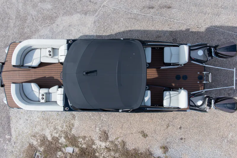 Slide: The Image of 2024 Manitou 25 LX SRW Dual Engine pontoon boat, aerial view, sleek design, spacious seating. - 3