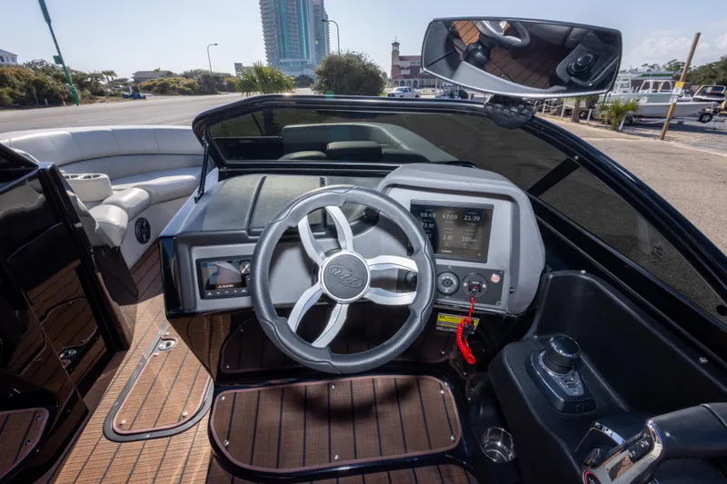 Slide: The Image of 2024 Manitou 25 LX SRW Dual Engine boat dashboard with steering wheel and controls. - 30