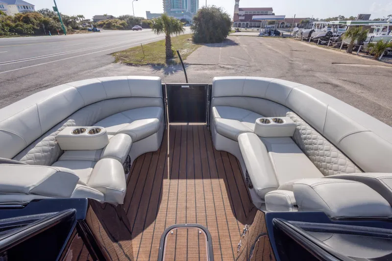 Slide: The Image of 2024 Manitou 25 LX SRW Dual Engine boat with luxurious seating and cup holders. - 31