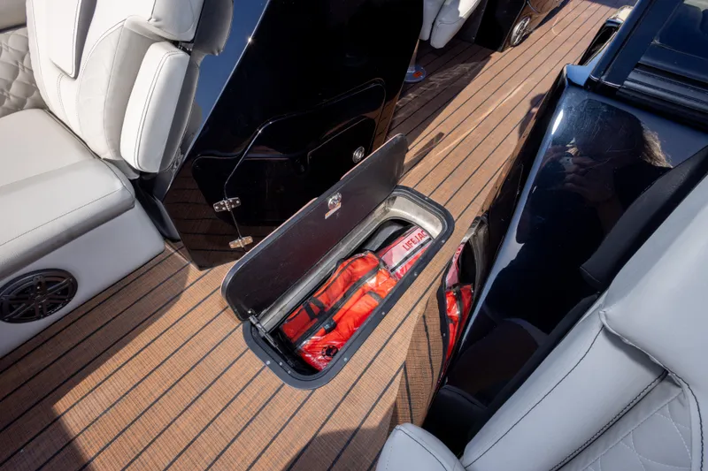 Slide: The Image of 2024 Manitou 25 LX SRW DUAL ENGINE boat interior with open storage compartment. - 37
