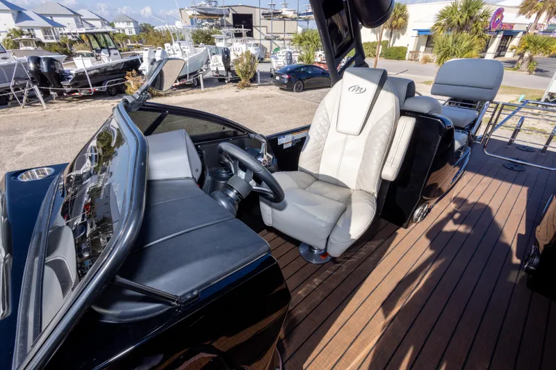 Slide: The Image of 2024 Manitou 25 LX SRW Dual Engine boat interior with luxurious seating and modern dashboard. - 38