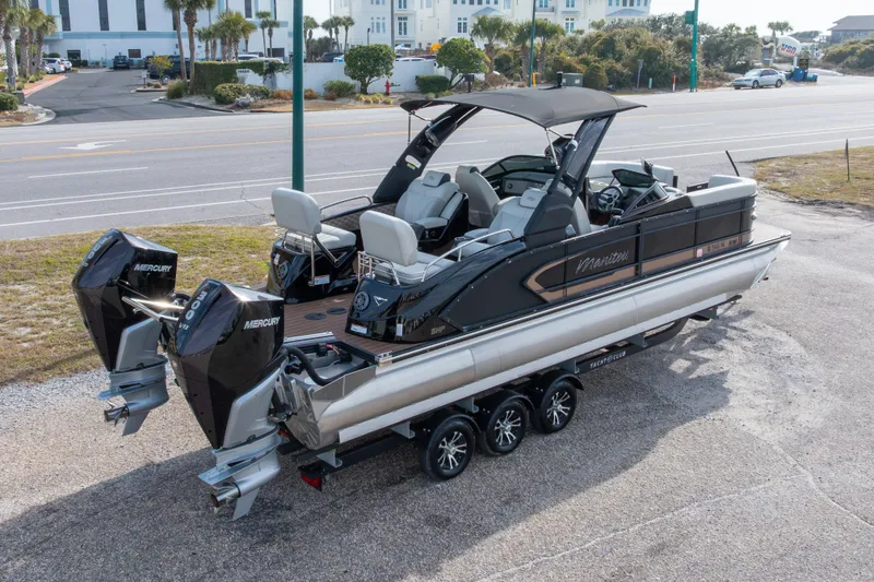 Slide: The Image of 2024 Manitou 25 LX SRW Dual Engine boat with twin Mercury engines on a trailer. - 4
