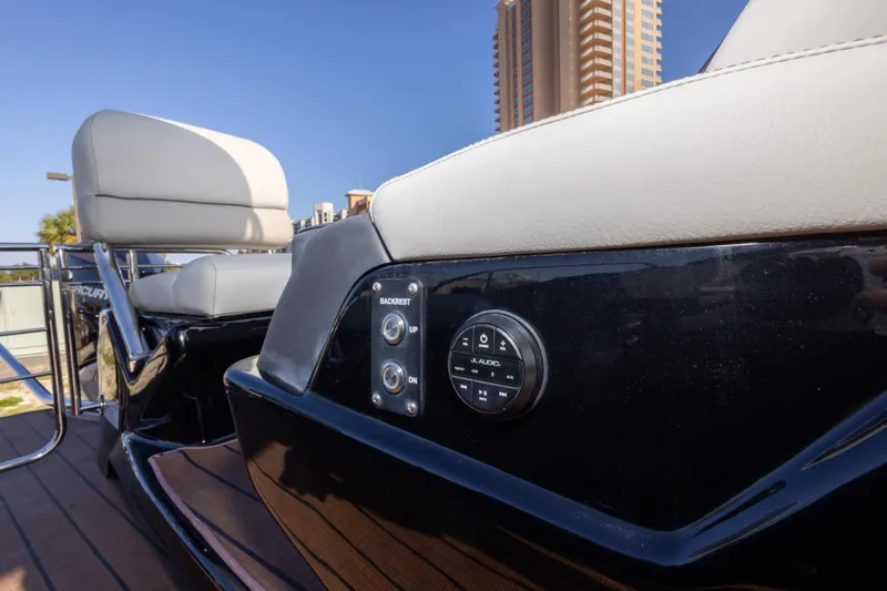 Slide: The Image of 2024 Manitou 25 LX SRW Dual Engine boat interior with audio controls and seating. - 41