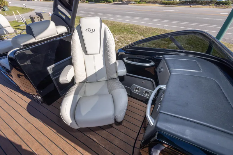 Slide: The Image of 2024 Manitou 25 LX SRW Dual Engine boat interior with luxury seating and dashboard. - 45