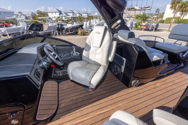 Slide: The Image of 2024 Manitou 25 LX SRW DUAL ENGINE boat interior with sleek seating and modern dashboard. - 46