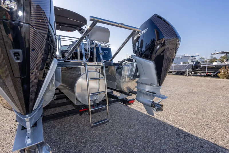 Slide: The Image of 2024 Manitou 25 LX SRW Dual Engine boat with Mercury outboards, rear view. - 47