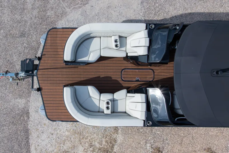 Slide: The Image of 2024 Manitou 25 LX SRW Dual Engine boat with luxurious seating and wooden deck. - 5