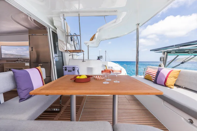 Slide: The Image of Luxurious Lagoon 38 yacht interior with dining area, colorful cushions, and ocean view, 2025 model. - 19