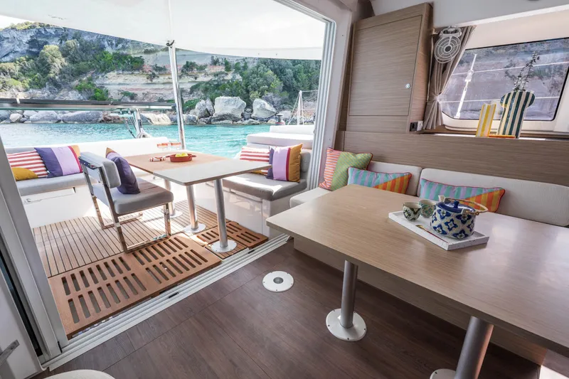 Slide: The Image of Luxurious interior of 2025 Lagoon 38 catamaran with colorful cushions and scenic ocean view. - 49