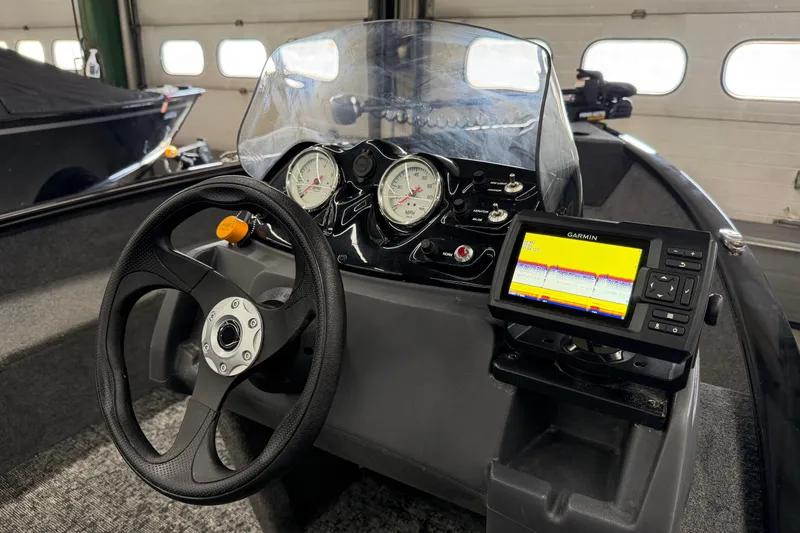 Slide: The Image of 2025 Tracker Super Guide V-16 SC boat dashboard with steering wheel and Garmin fishfinder. - 10