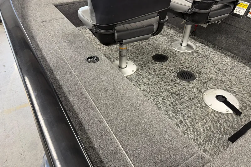 Slide: The Image of 2025 Tracker Super Guide V-16 SC boat interior with gray carpet and seating. - 13