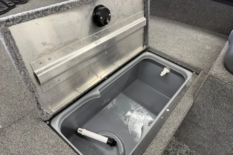 Slide: The Image of 2025 Tracker Super Guide V-16 SC boat storage compartment with open lid and gray interior. - 16