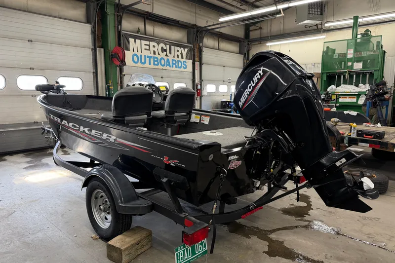 Slide: The Image of 2025 Tracker Super Guide V-16 SC boat with Mercury outboard in a garage setting. - 2