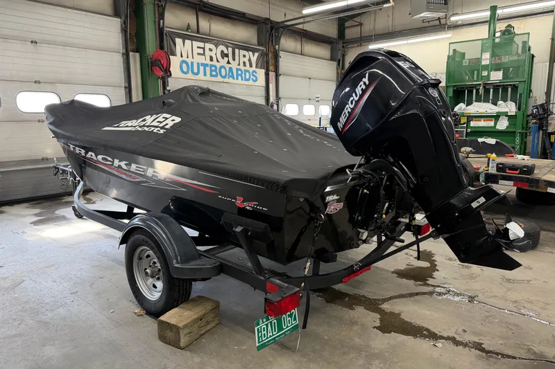 Slide: The Image of 2025 Tracker Super Guide V-16 SC boat with Mercury outboard in a garage. - 6