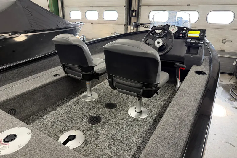 Slide: The Image of 2025 Tracker Super Guide V-16 SC boat interior with dual seats and control panel. - 7