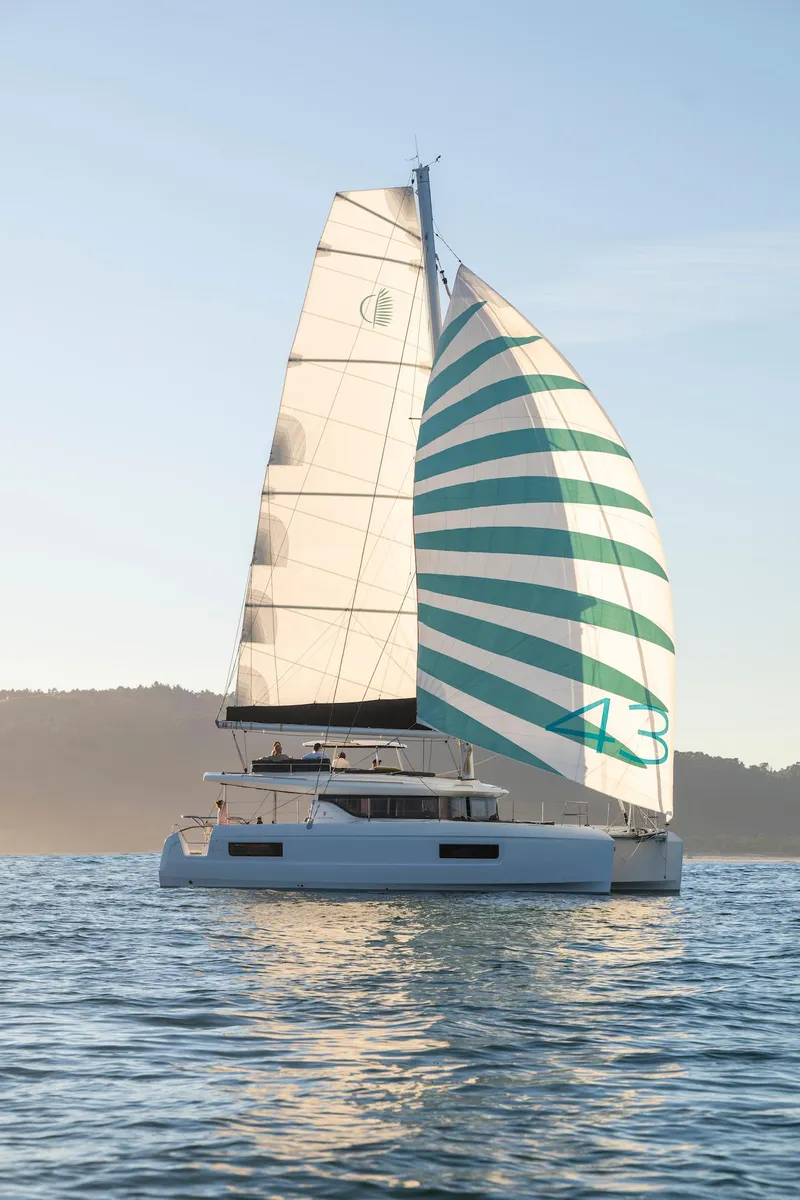 Slide: The Image of 2025 Lagoon 43 catamaran sailing on calm waters at sunset. - 46