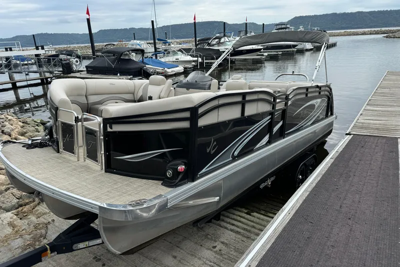 Slide: The Image of 2017 JC 23 Neptoon TT Sport pontoon boat docked at a marina. - 2