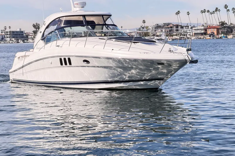 The Image of 2008 Sea Ray 40 Sundancer yacht on calm water, coastal background. - 0