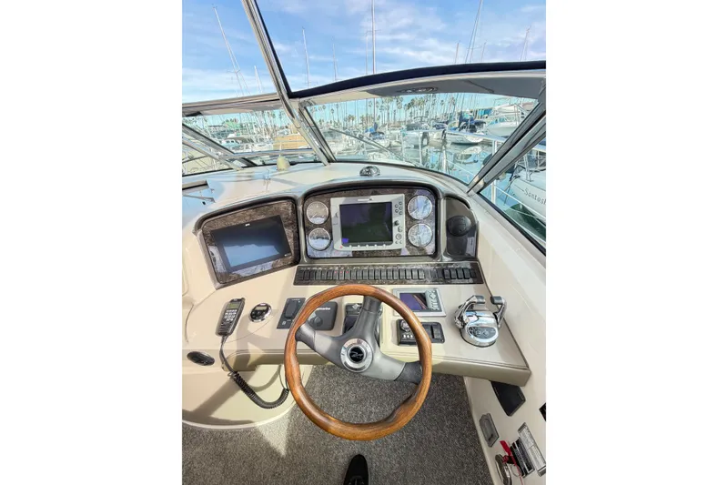 Slide: The Image of 2008 Sea Ray 40 Sundancer helm with navigation controls and marina view. - 12