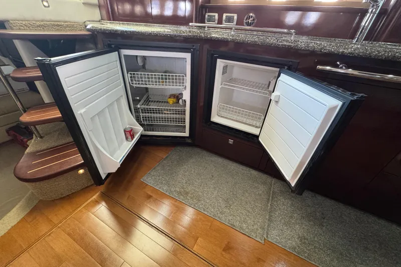 Slide: The Image of Interior of 2008 Sea Ray 40 Sundancer with open dual refrigerators and wooden flooring. - 39