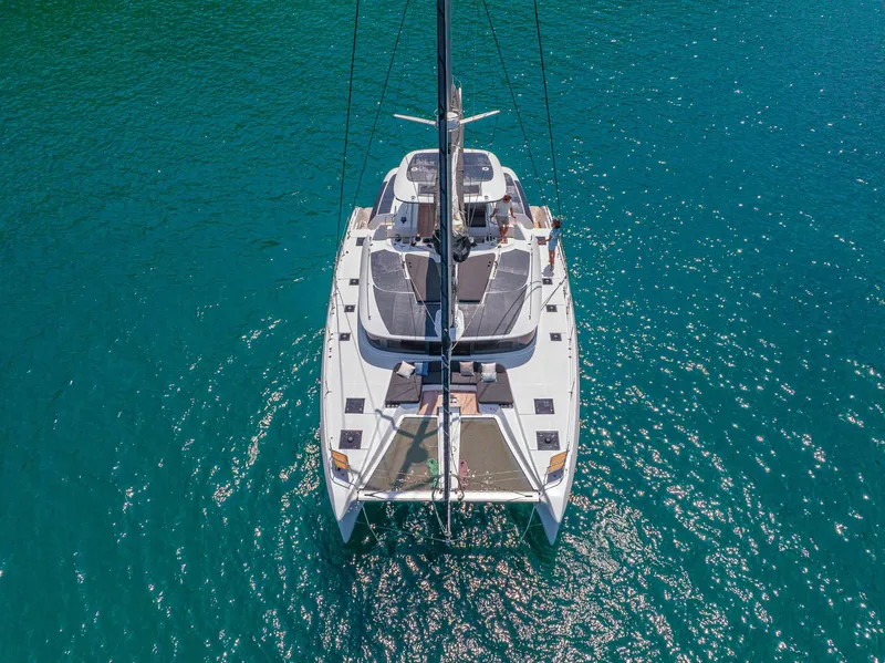 Slide: The Image of 2025 Lagoon 51 ICONIC catamaran on clear blue water, aerial view. - 10