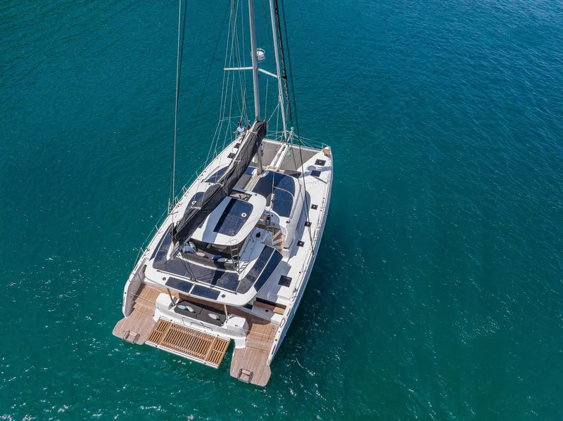 Slide: The Image of 2025 Lagoon 51 ICONIC catamaran sailing on clear blue water. - 8