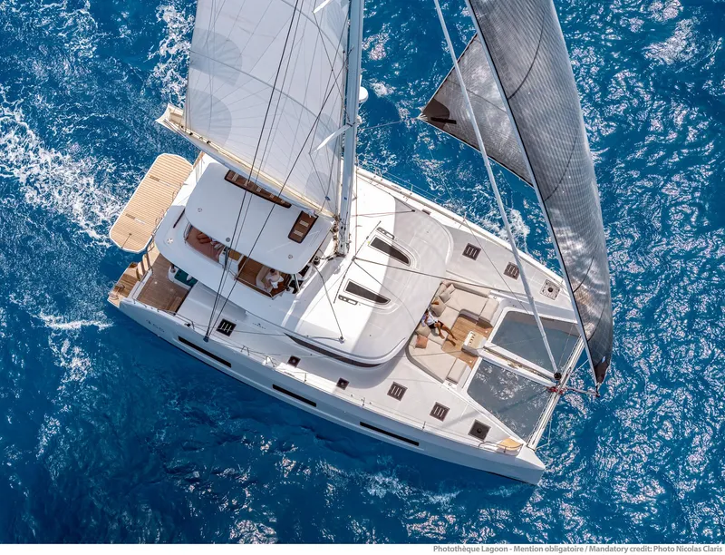 Slide: The Image of Aerial view of 2025 Lagoon 55 catamaran sailing on blue ocean waters. - 2
