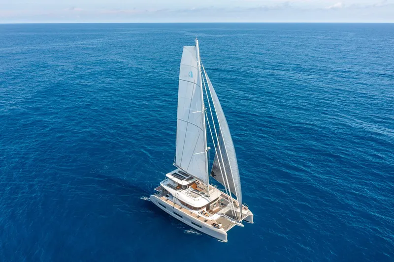 Slide: The Image of 2025 Lagoon 60 catamaran sailing on open ocean under clear skies. - 3