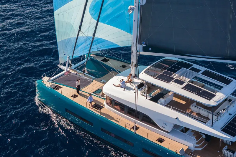 Slide: The Image of 2026 Lagoon Eighty 2 yacht sailing on open sea with people on deck. - 2