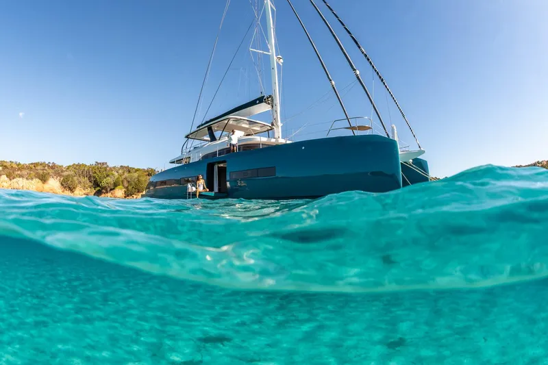 Slide: The Image of 2026 Lagoon Eighty 2 yacht in clear turquoise water, sunny day, coastal backdrop. - 5