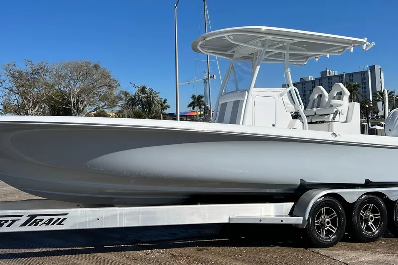 Slide: The Image of 2026 Contender 29 Bay boat on trailer under clear blue sky. - 2