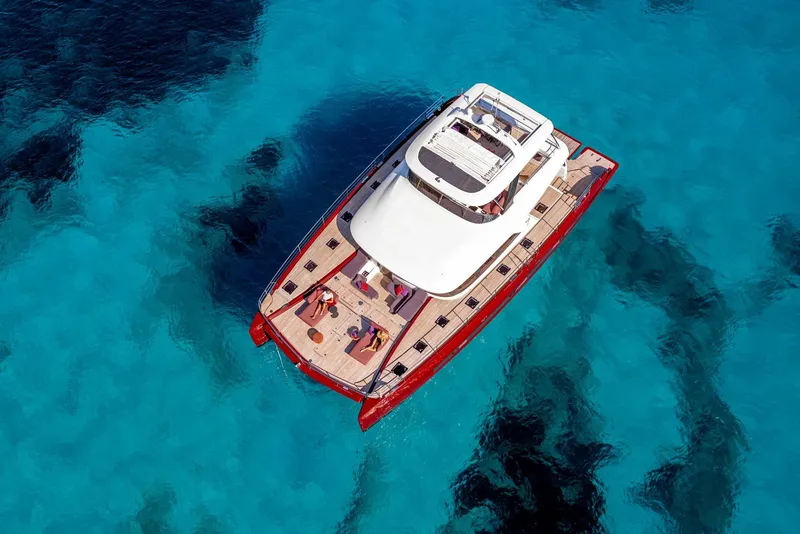 Slide: The Image of Aerial view of 2025 Lagoon SIXTY 7 yacht on clear blue water. - 2