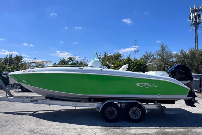 Slide: The Image of 2006 Baja 250 Sportfish boat with green hull on trailer under clear blue sky. - 1