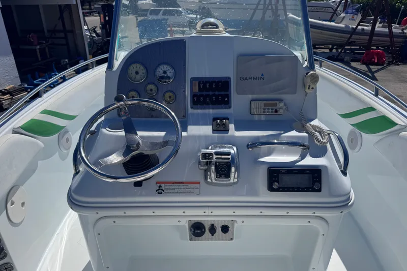 Slide: The Image of 2006 Baja 250 Sportfish boat dashboard with steering wheel and navigation instruments. - 13