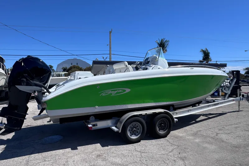 Slide: The Image of 2006 Baja 250 Sportfish boat with green hull on trailer, parked outdoors. - 3