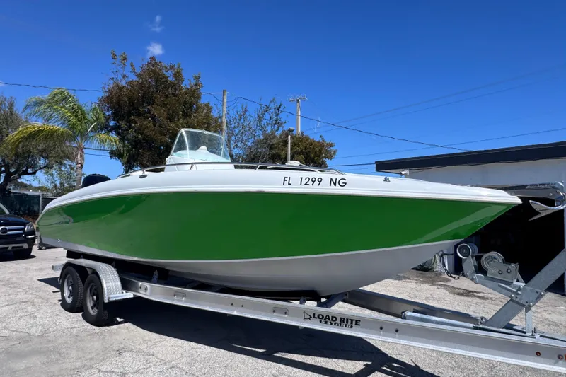 Slide: The Image of 2006 Baja 250 Sportfish boat on trailer, green hull, clear sky background. - 4