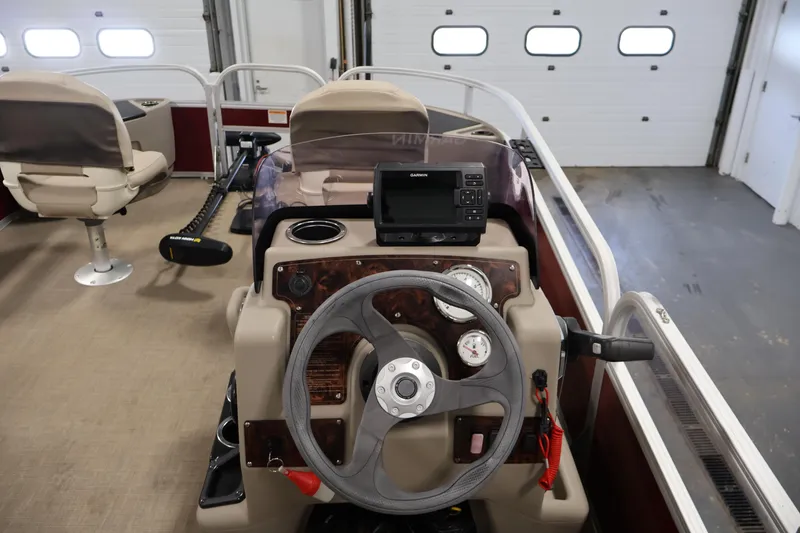 Slide: The Image of 2021 Sun Tracker Bass Buggy 18 DLX boat interior with steering wheel and navigation system. - 24