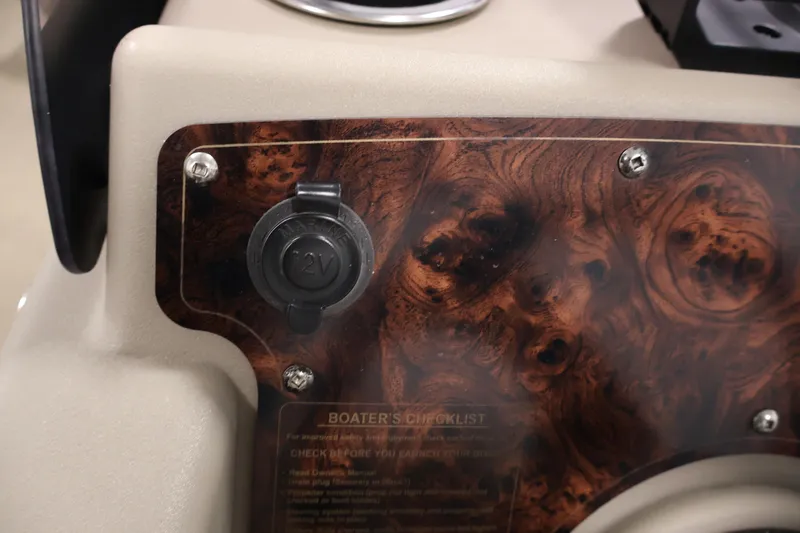 Slide: The Image of 2021 Sun Tracker Bass Buggy 18 DLX dashboard with 12V outlet and wood grain finish. - 28