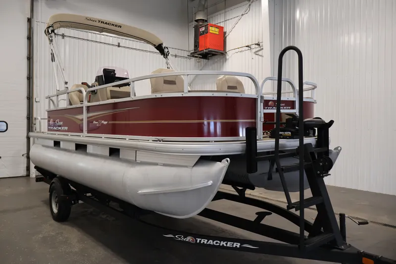 Slide: The Image of 2021 Sun Tracker Bass Buggy 18 DLX pontoon boat on trailer in indoor storage. - 3
