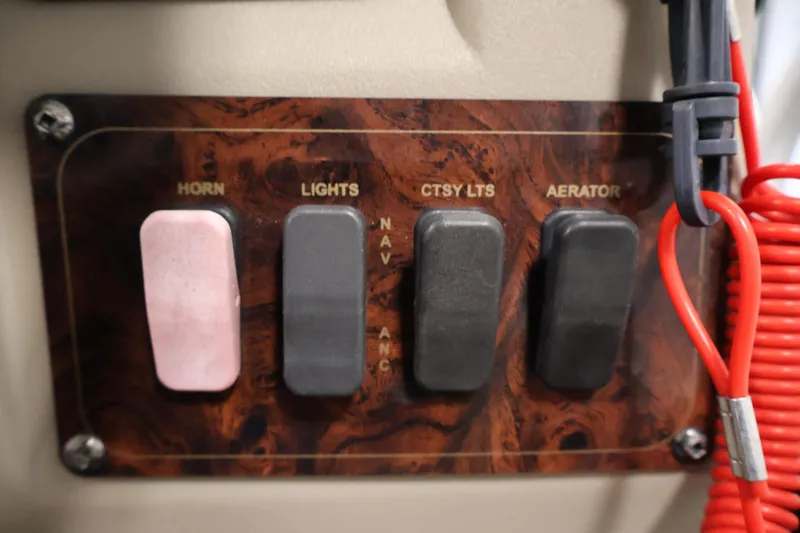 Slide: The Image of Control panel of a 2021 Sun Tracker Bass Buggy 18 DLX with switches for horn, lights, and aerator. - 30