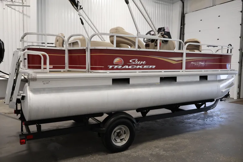 Slide: The Image of 2021 Sun Tracker Bass Buggy 18 DLX pontoon boat on trailer in indoor setting. - 4