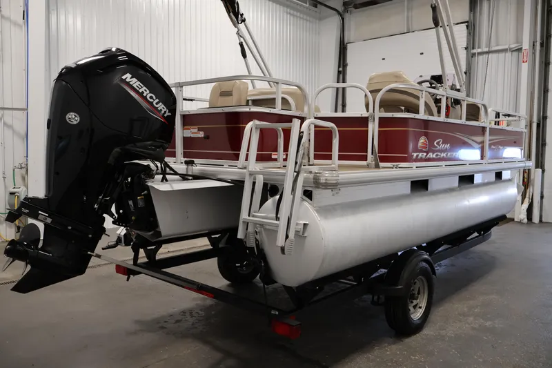 Slide: The Image of 2021 Sun Tracker Bass Buggy 18 DLX pontoon boat with Mercury outboard motor in a garage. - 5