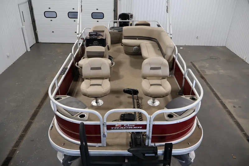 Slide: The Image of 2021 Sun Tracker Bass Buggy 18 DLX pontoon boat with beige seating in a garage. - 9